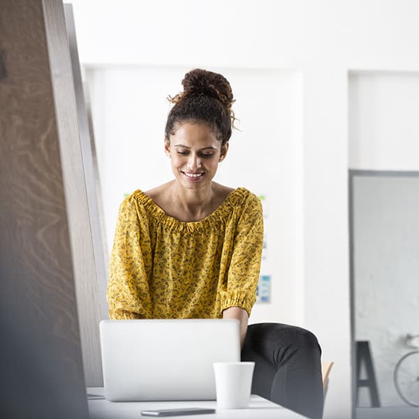 Lady reading about guardian anytime on her laptop.