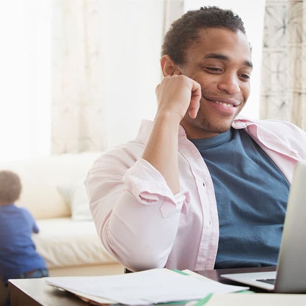 Young man working from home with his child during the pandemic .