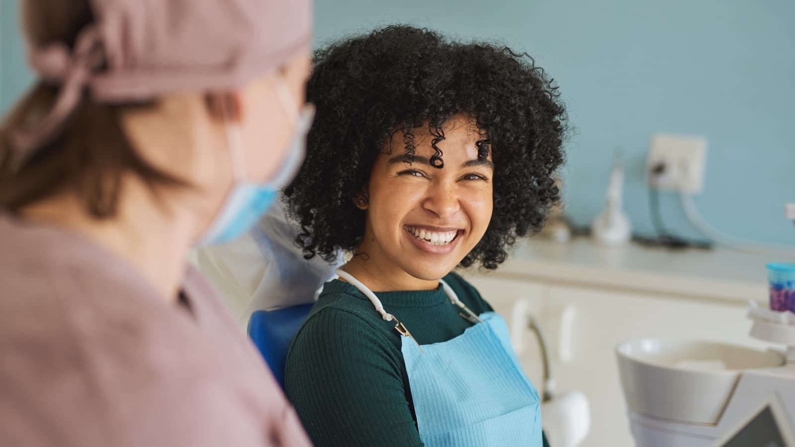 A girl smiling at a dentist before a check-up.