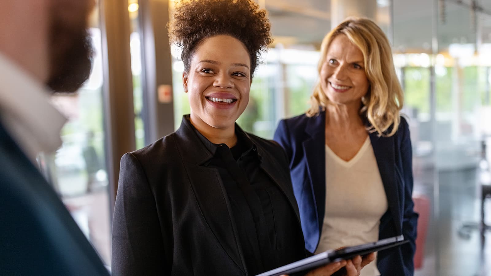 Woman talks with two colleagues at work