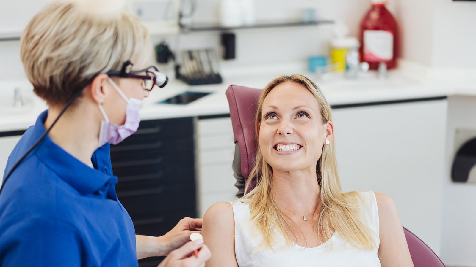 Dentist speaking to patient in chair Dentist speaking to patient in chair