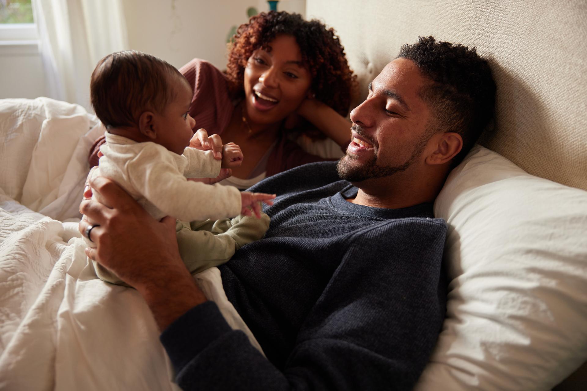 Young parents playing with their baby before bedtime.