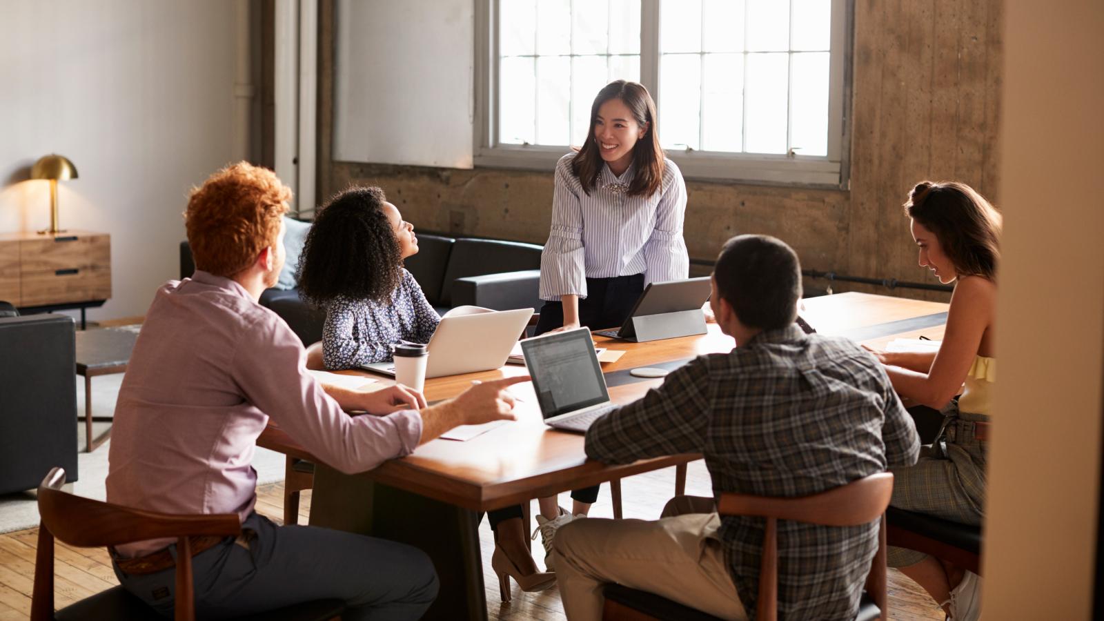 Woman addressing colleagues at meeting