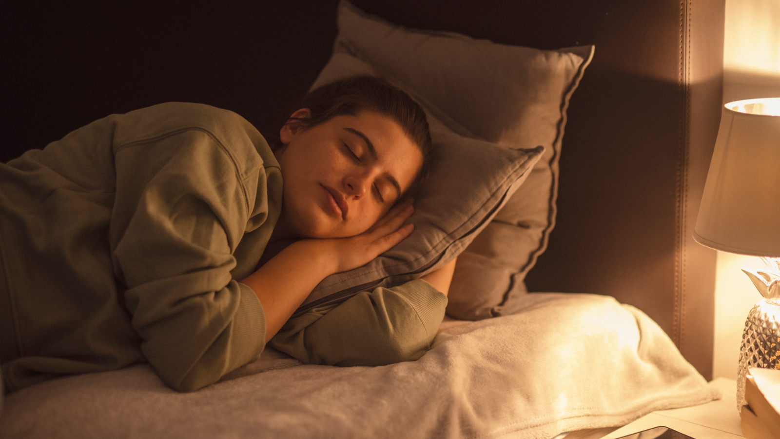 Lamp illuminating sleeping woman at night